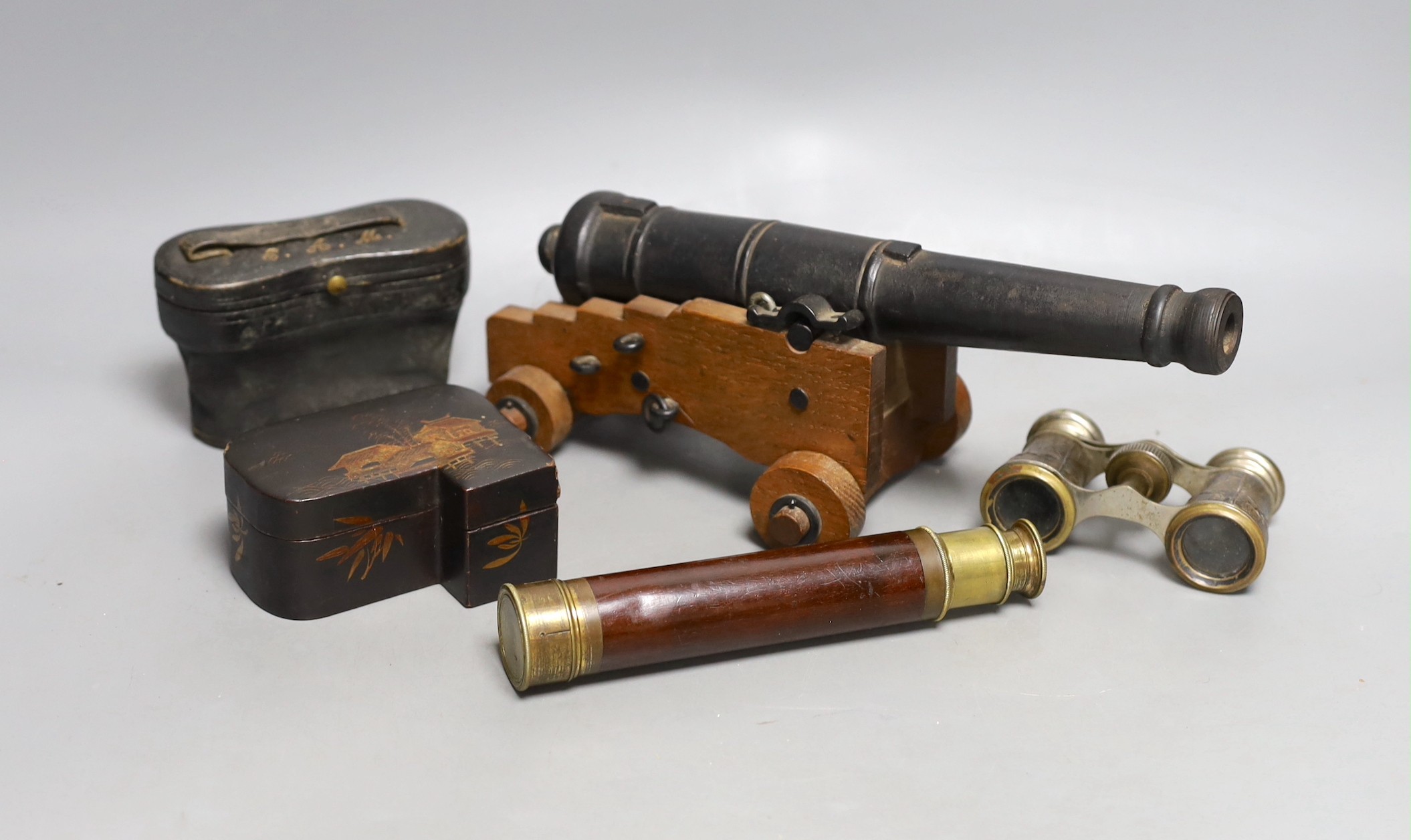 A model cast iron cannon on oak carriage, 26 cm long, two pairs of opera glasses, a telescope and lacquer box